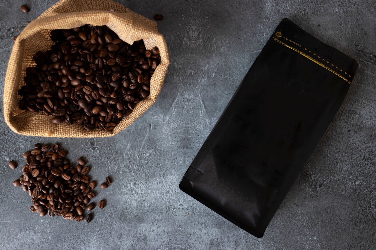 coffee beans and black bag of coffee